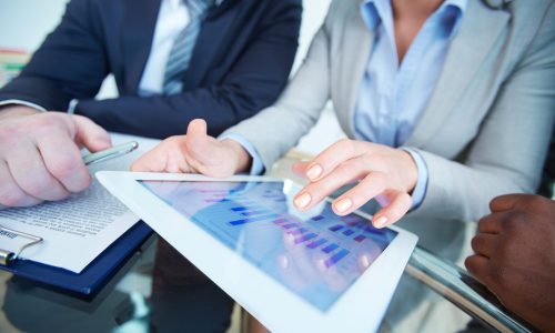Human hands during discussion of business document in touchscreen at meeting